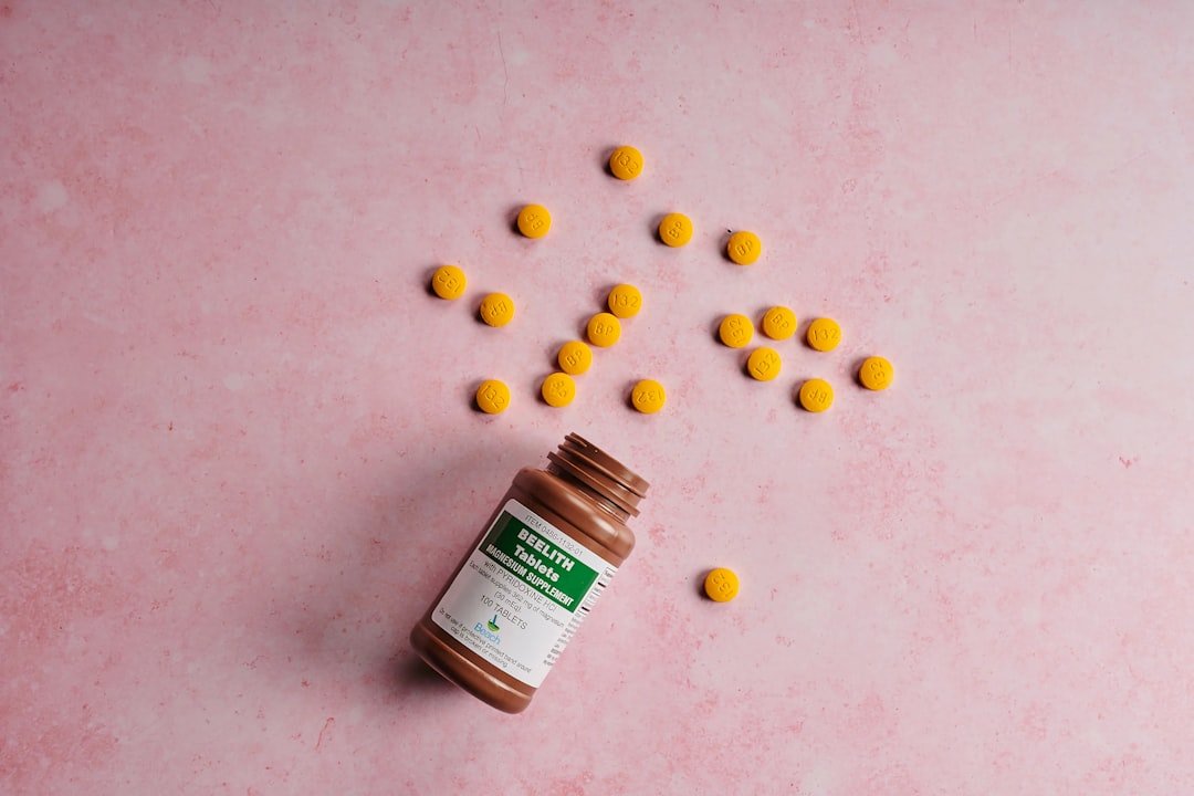 a bottle of pills sitting on top of a pink surface