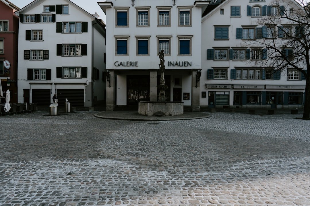 a large white building sitting on top of a cobblestone street